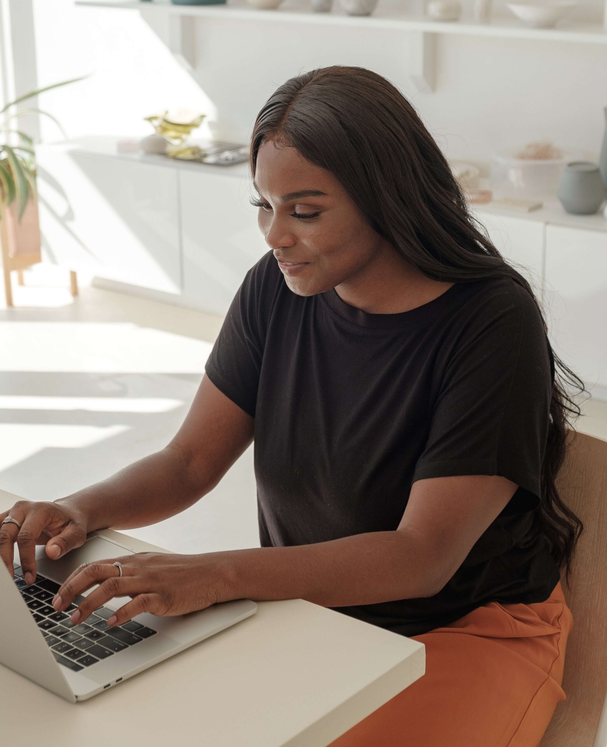 young-woman-smiles-as-she-checks-on-her-online-store-2 smaller